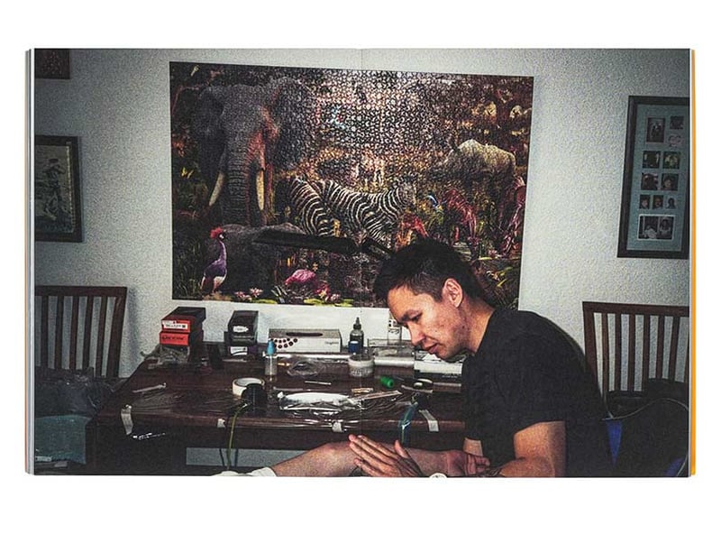 A man sits at a desk filled with various items, Inuuteq Storch