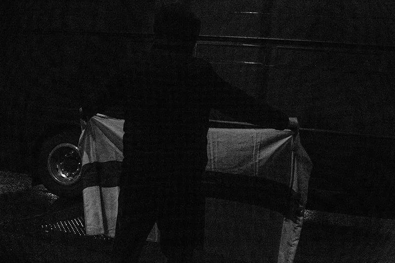 High contrast black and white photo by Alejandro Acin showing dark silhouette or someone holding an England flag