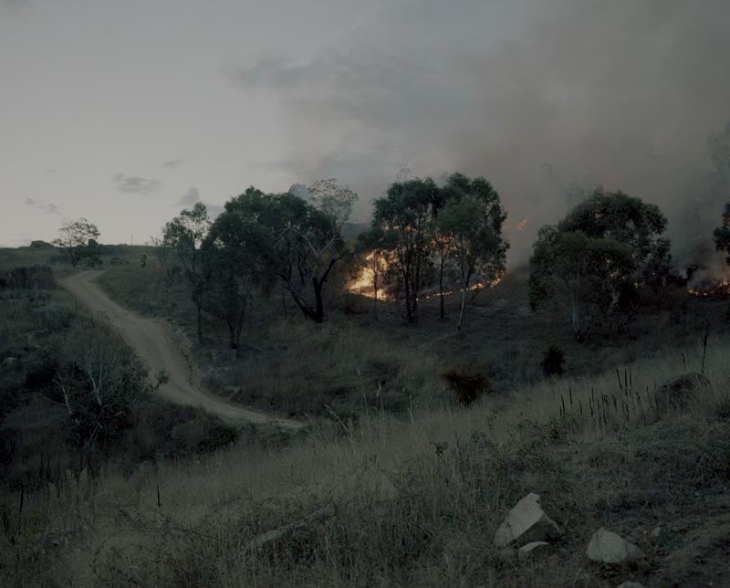 An Australian farm landscape with bush fires in the distance