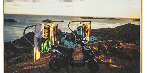 View of a rocky seaside landscape with washing lines and a parked bike, Inuuteq Storch